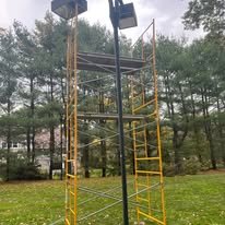 Instalación de luminaria en poste desde un andamio